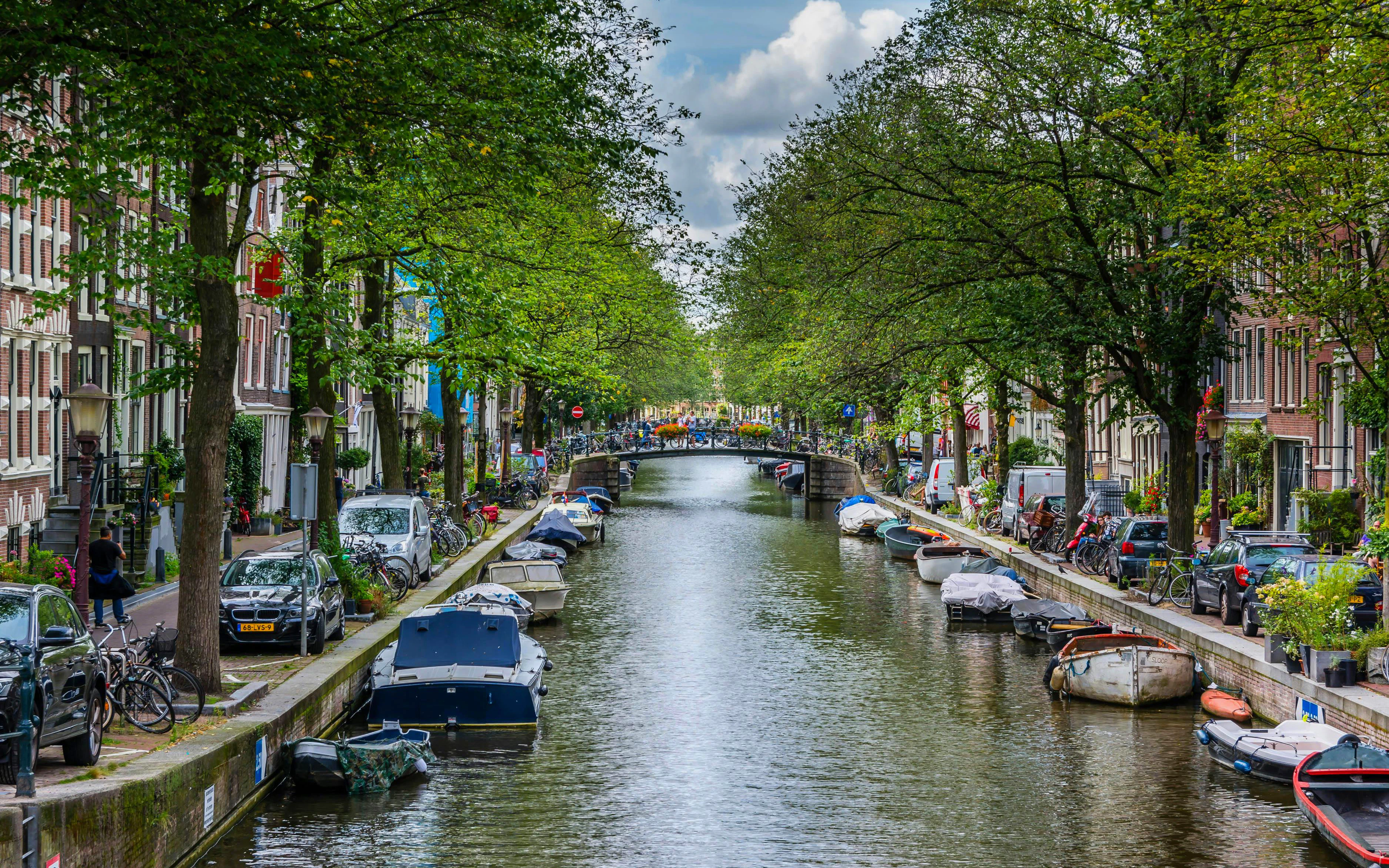 Egelantiersgracht canal in Amsterdam lined with boats and trees.