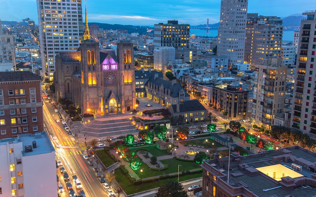 San Francisco skyline at sunset with Grace Cathedral and city lights.