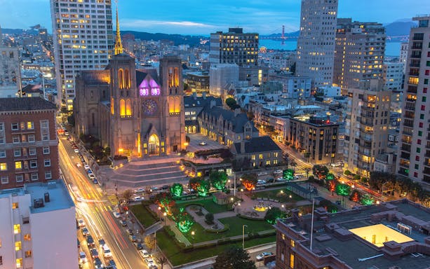 San Francisco skyline at sunset with Grace Cathedral and city lights.