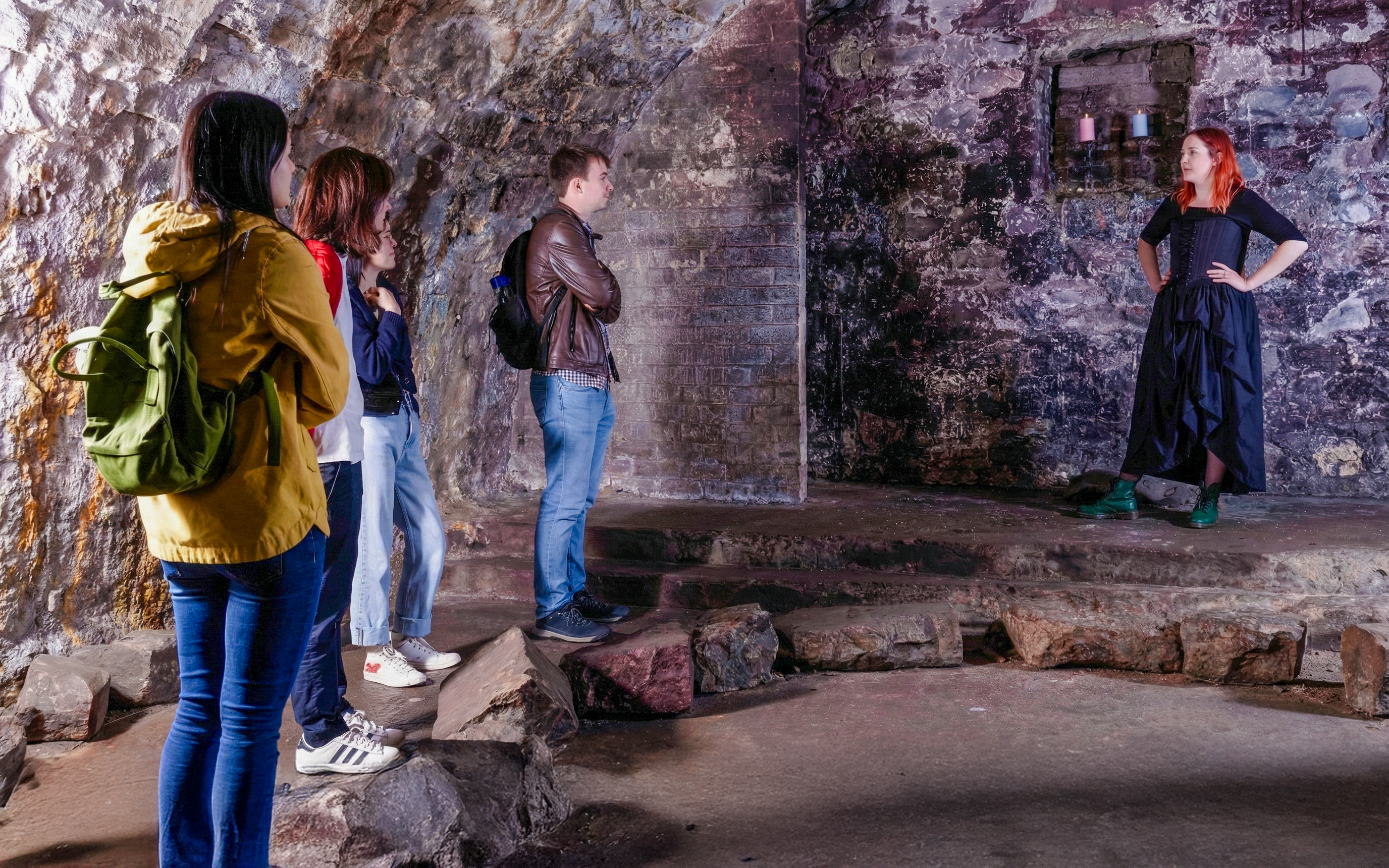 Tour group listening to a guide in the historic Edinburgh Vaults.