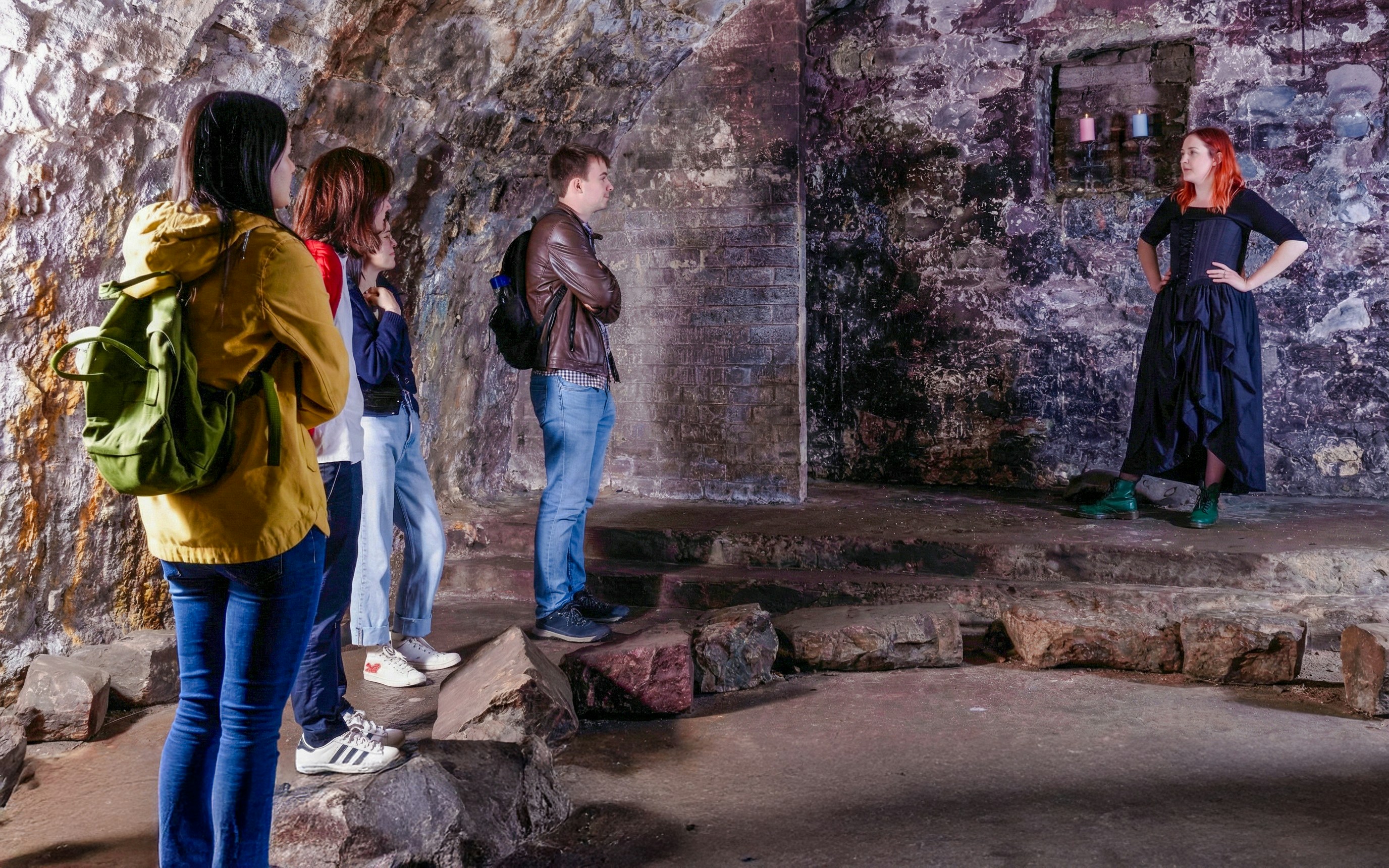 Tour group listening to a guide in the historic Edinburgh Vaults.