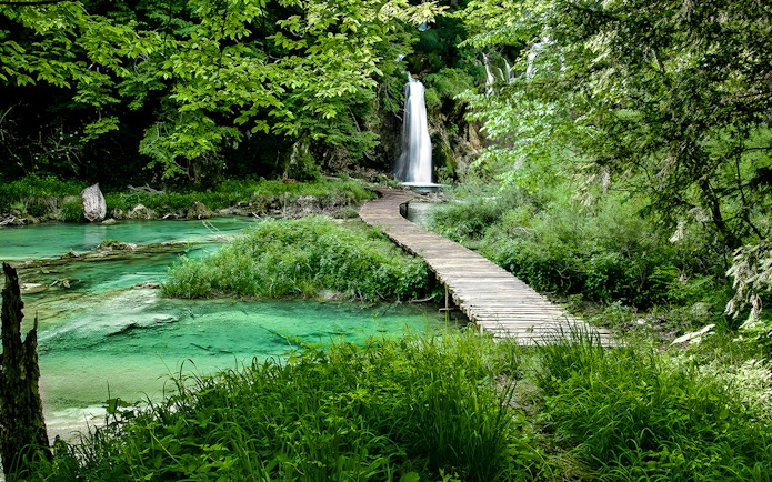 Wooden path leading to a waterfall at Plitvice Lakes National Park, Croatia.