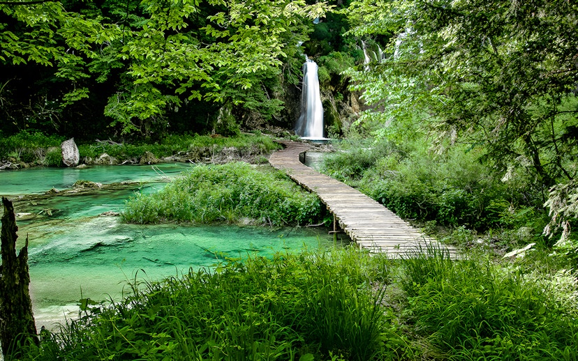 Wooden path leading to a waterfall at Plitvice Lakes National Park, Croatia.