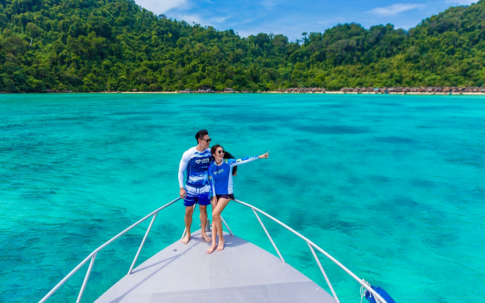 Couple on speedboat enjoying view of Surin Island's turquoise waters, Phuket day trip.