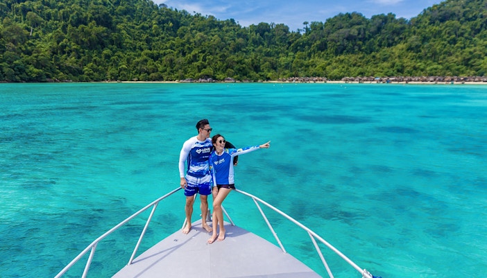 Couple on speedboat enjoying view of Surin Island's turquoise waters, Phuket day trip.