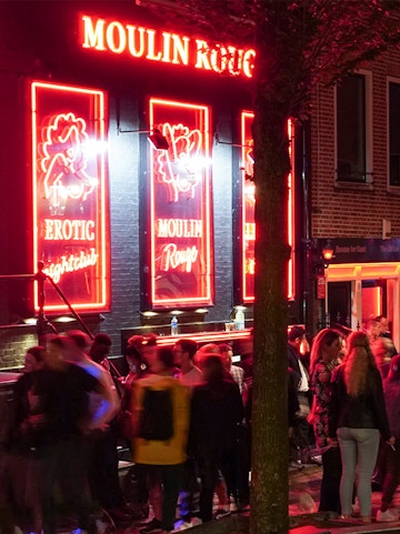 Crowd outside Moulin Rouge in Amsterdam's Red Light District at night.