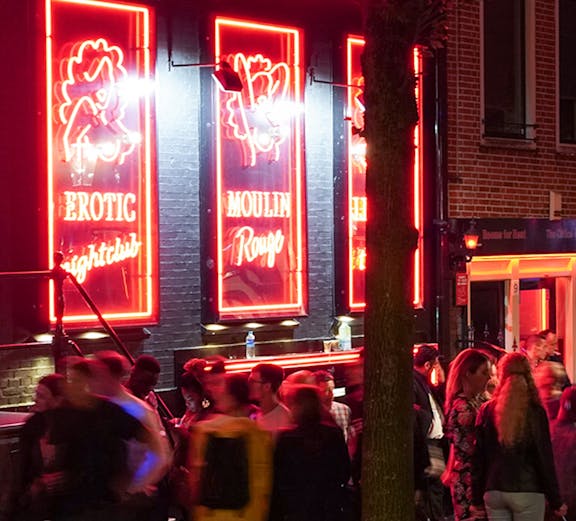 Crowd outside Moulin Rouge in Amsterdam's Red Light District at night.