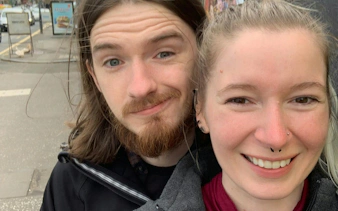 Two people smiling on a street in Glasgow's West End, part of a self-guided city exploration game.