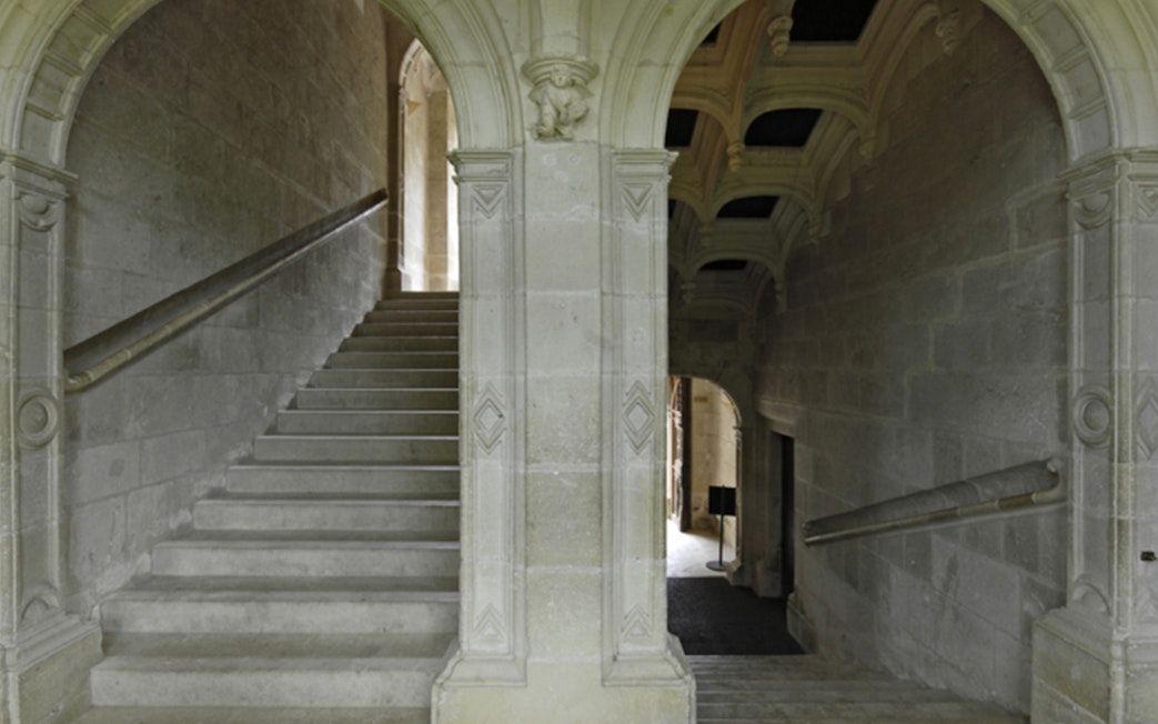 Grand staircase with stone arches at Azay-le-Rideau, France.