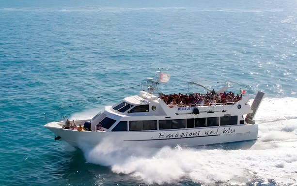 Ferry carrying passengers from Peschici to Tremiti Islands across blue sea.