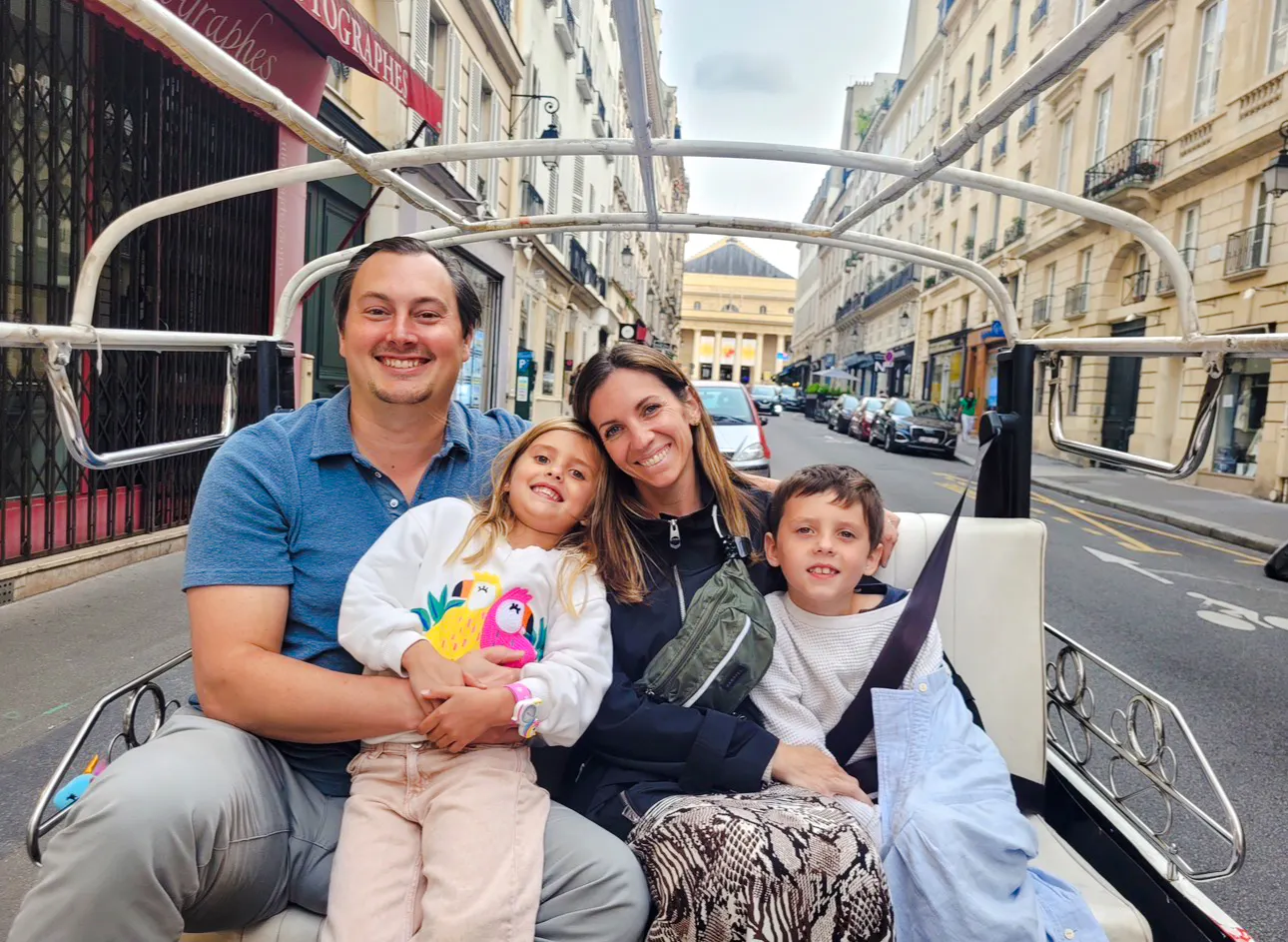 Family enjoying a private Paris tour by electric tuk-tuk with a local guide.