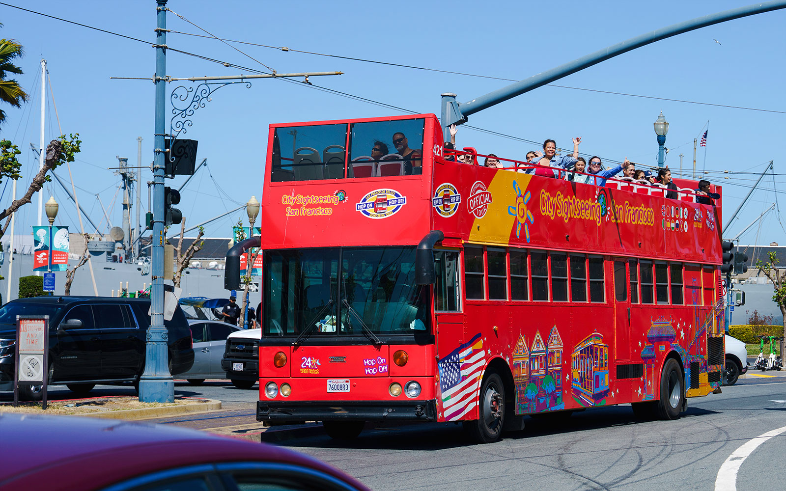 Open-top sightseeing bus in San Francisco with tourists on board.