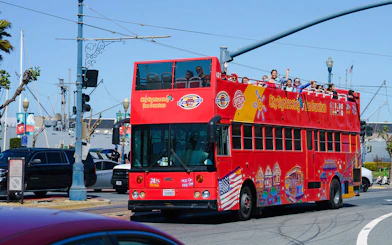 Open-top sightseeing bus in San Francisco with tourists on board.