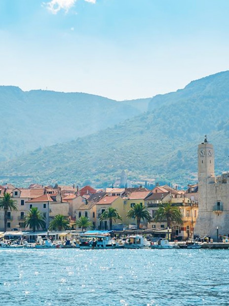 Coastal town view with boats and clock tower, Split, Croatia.