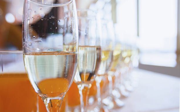 Champagne glasses lined up on a table, ready for a celebration.