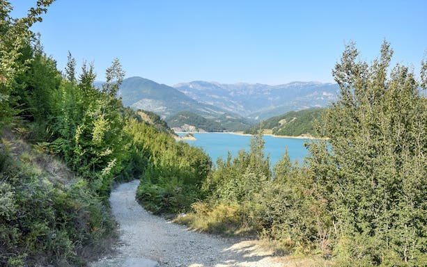 Bovilla Lake view with surrounding mountains and forested path during 4x4 offroad tour.