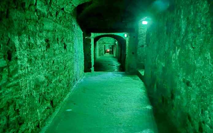 Underground passage in Niddry Street vaults, Edinburgh, with stone walls and arched ceilings.