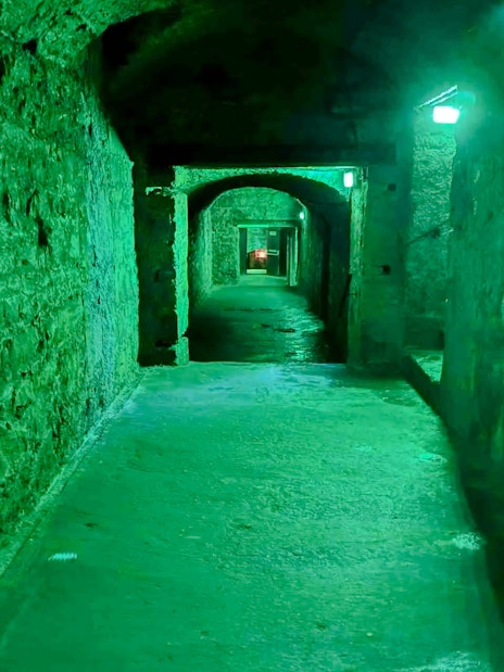 Underground passage in Niddry Street vaults, Edinburgh, with stone walls and arched ceilings.