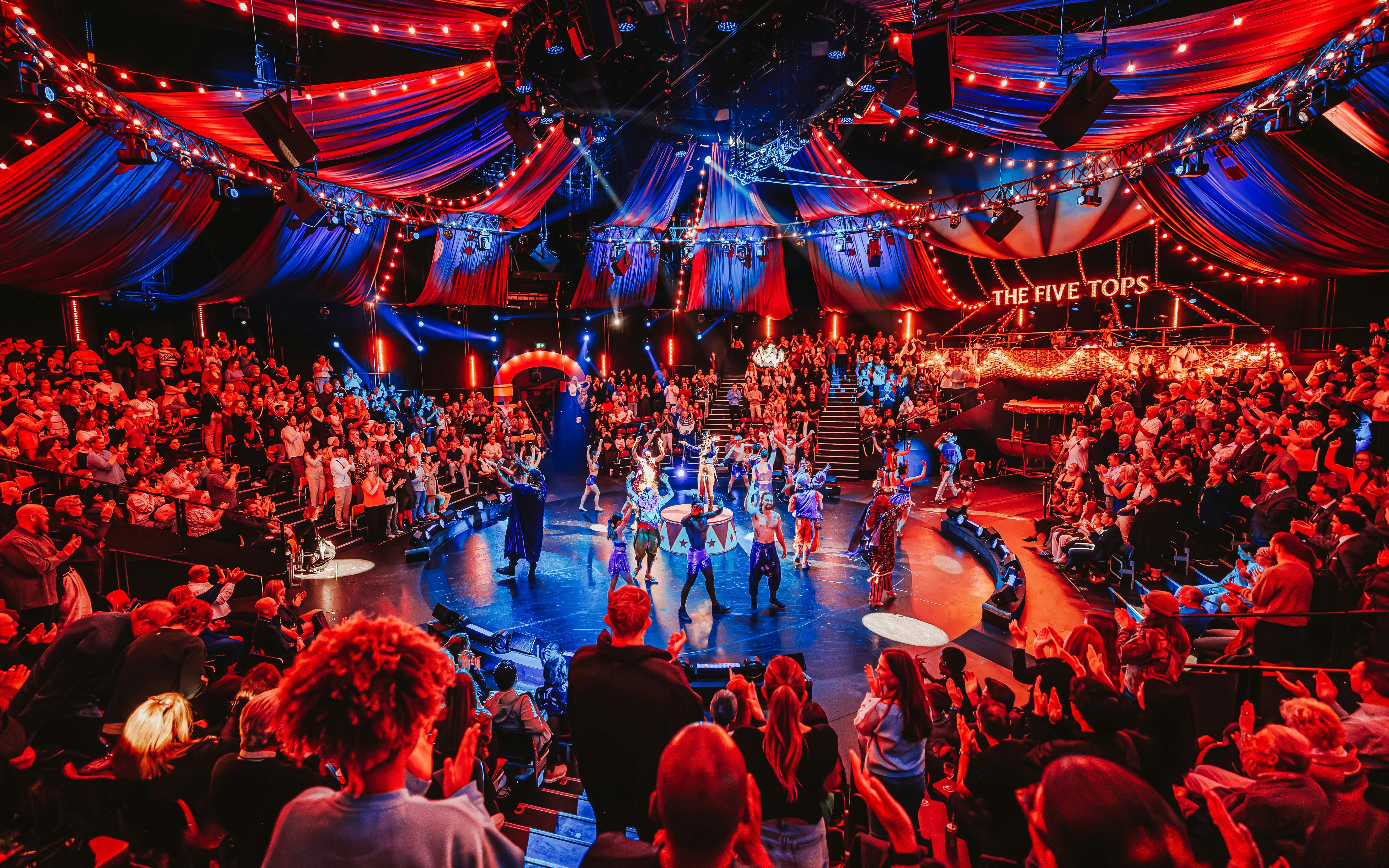 Stage performance of Come Alive Westend with vibrant audience and colorful lights.