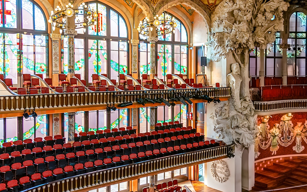 Interior of Palau de la Música Catalana with stained glass windows and ornate sculptures, Barcelona.