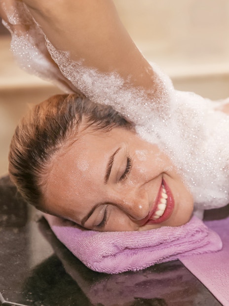 Woman enjoying foam massage in a hammam spa.
