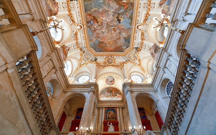Ceiling fresco and ornate architecture inside the Royal Palace of Madrid.