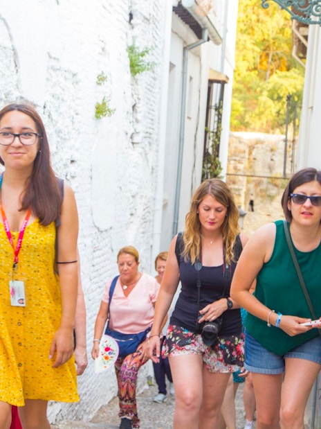Tour guide leading tourists through narrow streets in Granada.