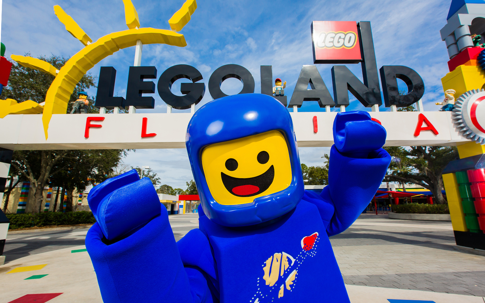 Lego character in front of Legoland Florida entrance sign.