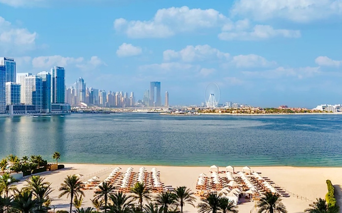 Beachfront view from Fairmont Hotel overlooking Dubai skyline and Ferris wheel.