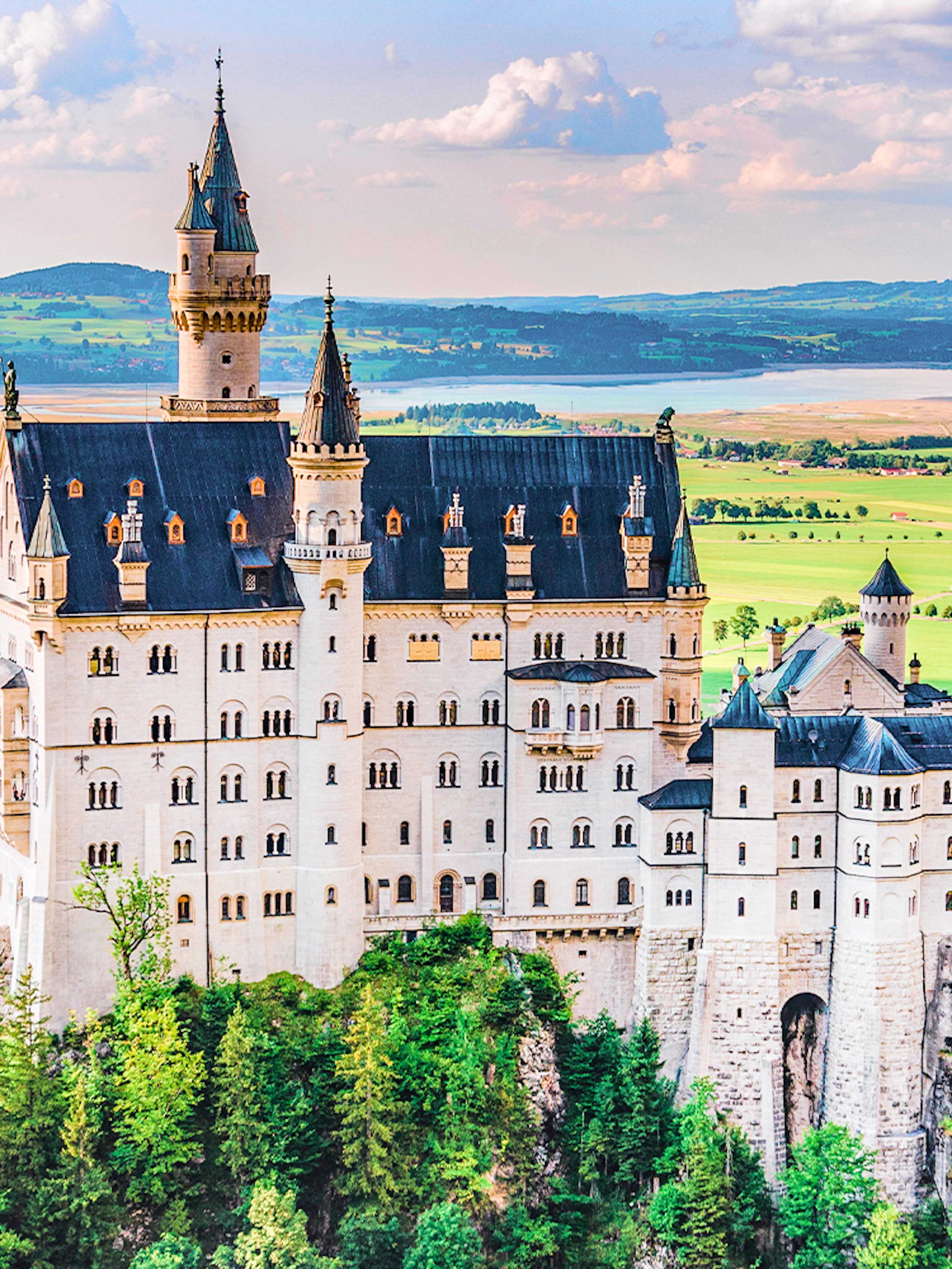 Neuschwanstein Castle in Bavaria, Germany, surrounded by lush green landscape.