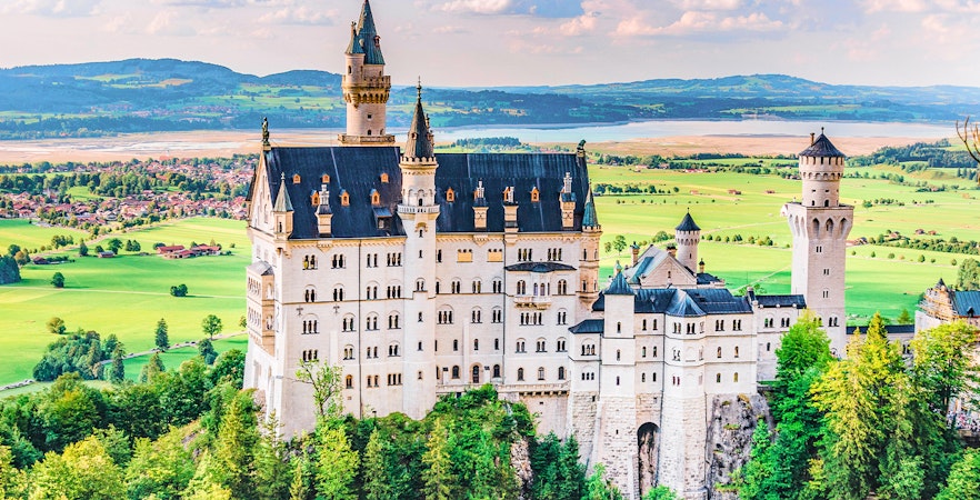 Neuschwanstein Castle in Bavaria, Germany, surrounded by lush green landscape.