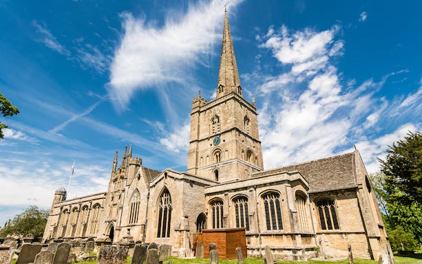 St. John the Baptist Church in Burford with its tall spire and historic architecture.