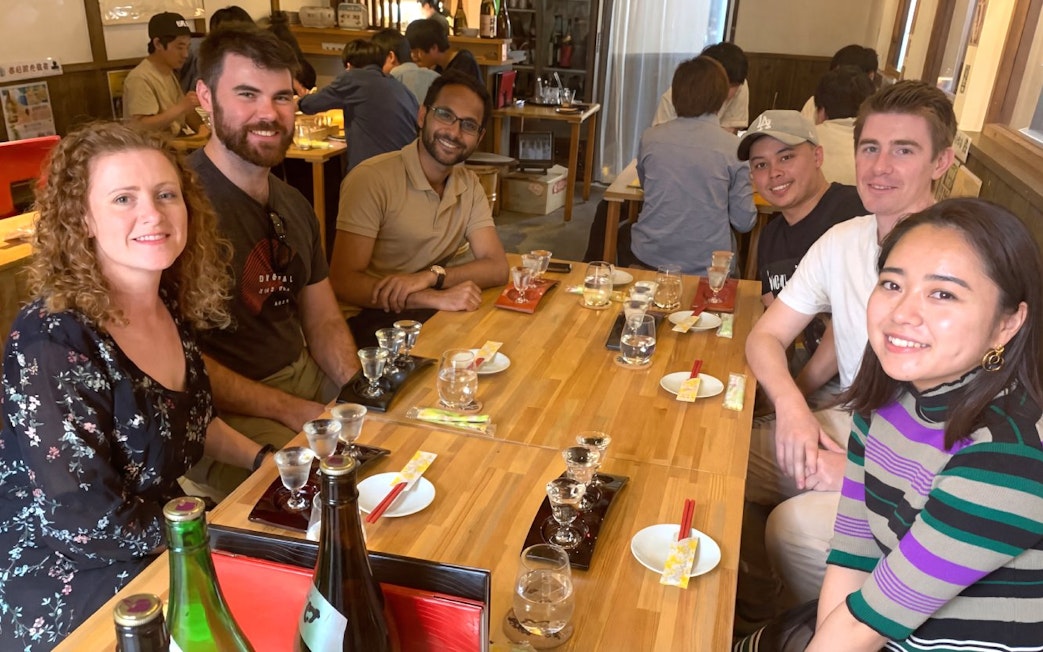 Group enjoying sake tasting at a Kyoto brewery during a walking tour.
