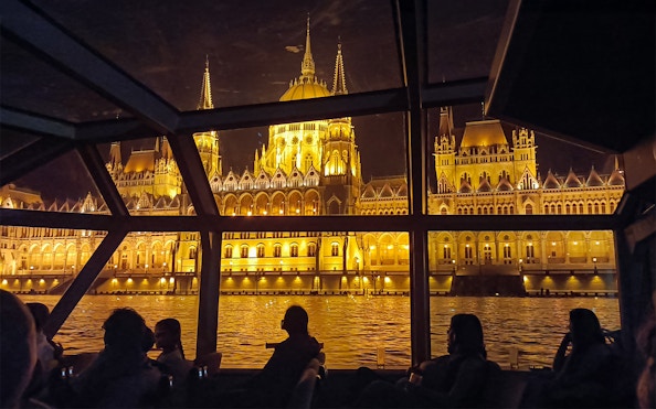 Hungarian Parliament Building illuminated at night viewed from a Budapest Danube River dinner cruise.