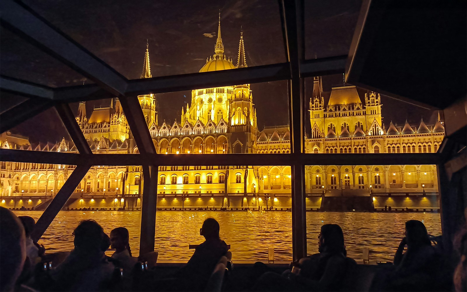 Hungarian Parliament Building illuminated at night viewed from a Budapest Danube River dinner cruise.