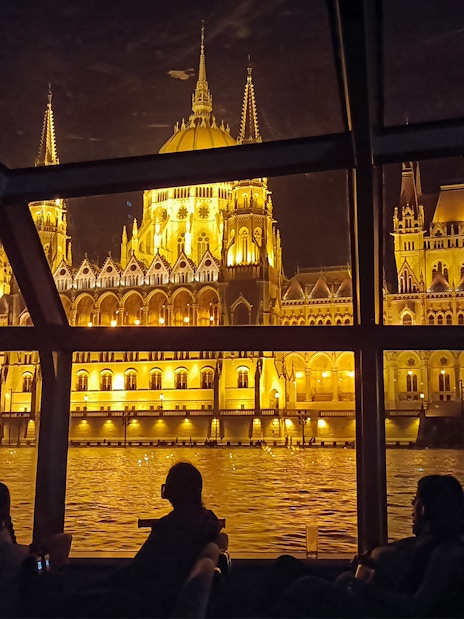 Hungarian Parliament Building illuminated at night viewed from a Budapest Danube River dinner cruise.