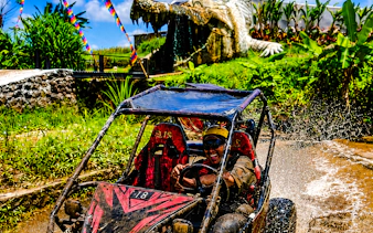 Buggy driving through muddy water near Crocodile Cave in Ubud, Bali.