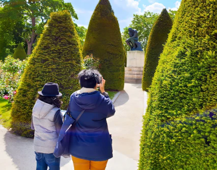 Visitors exploring the garden at Rodin Museum with The Thinker statue in view.