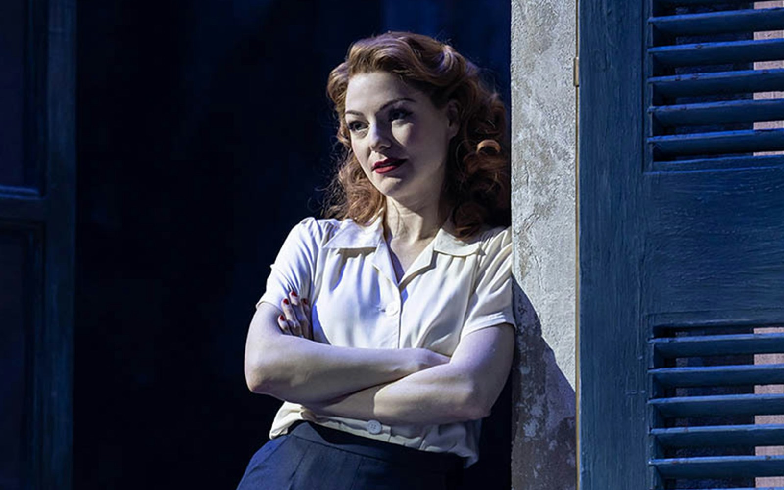 Performer in "Aspects of Love" leaning against a wall on stage.
