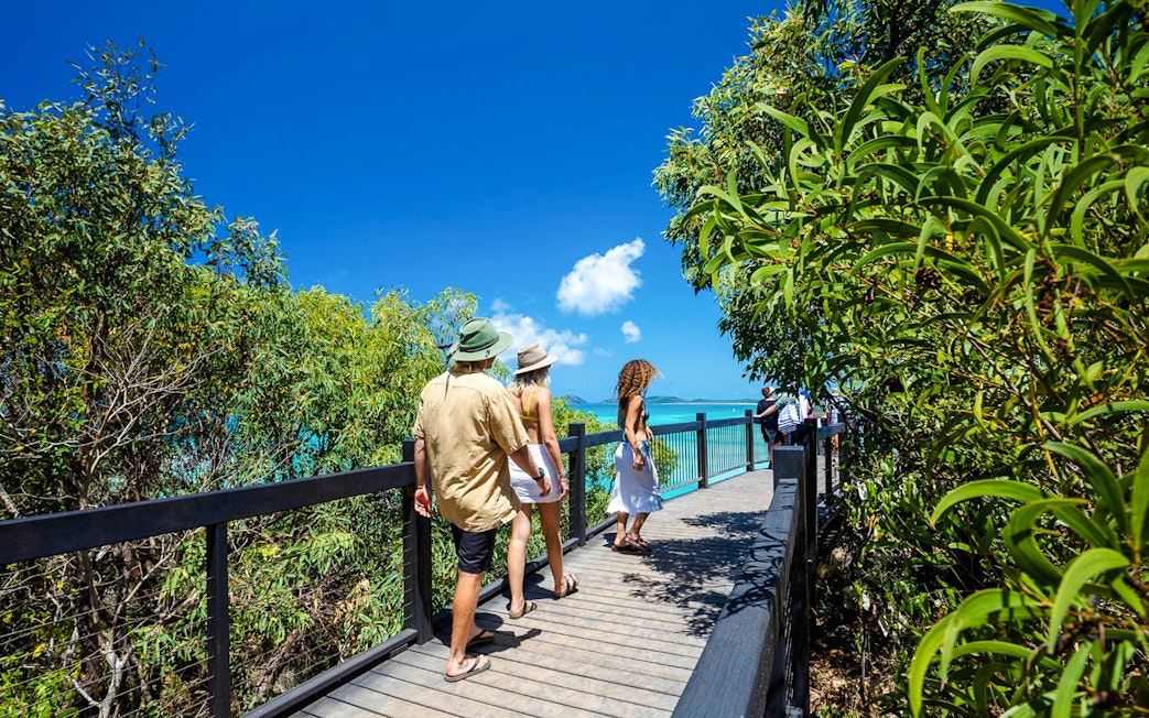 Visitors walking on a boardwalk towards Hill Inlet lookout, Whitsundays.