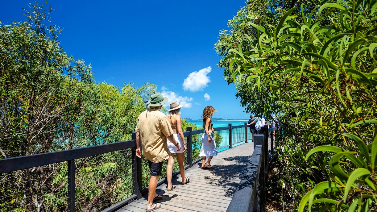 Visitors walking on a boardwalk towards Hill Inlet lookout, Whitsundays.