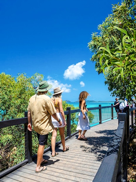 Visitors walking on a boardwalk towards Hill Inlet lookout, Whitsundays.