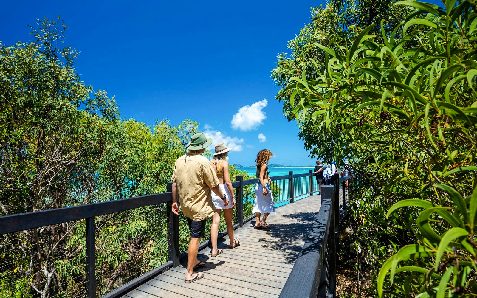 Visitors walking on a boardwalk towards Hill Inlet lookout, Whitsundays.