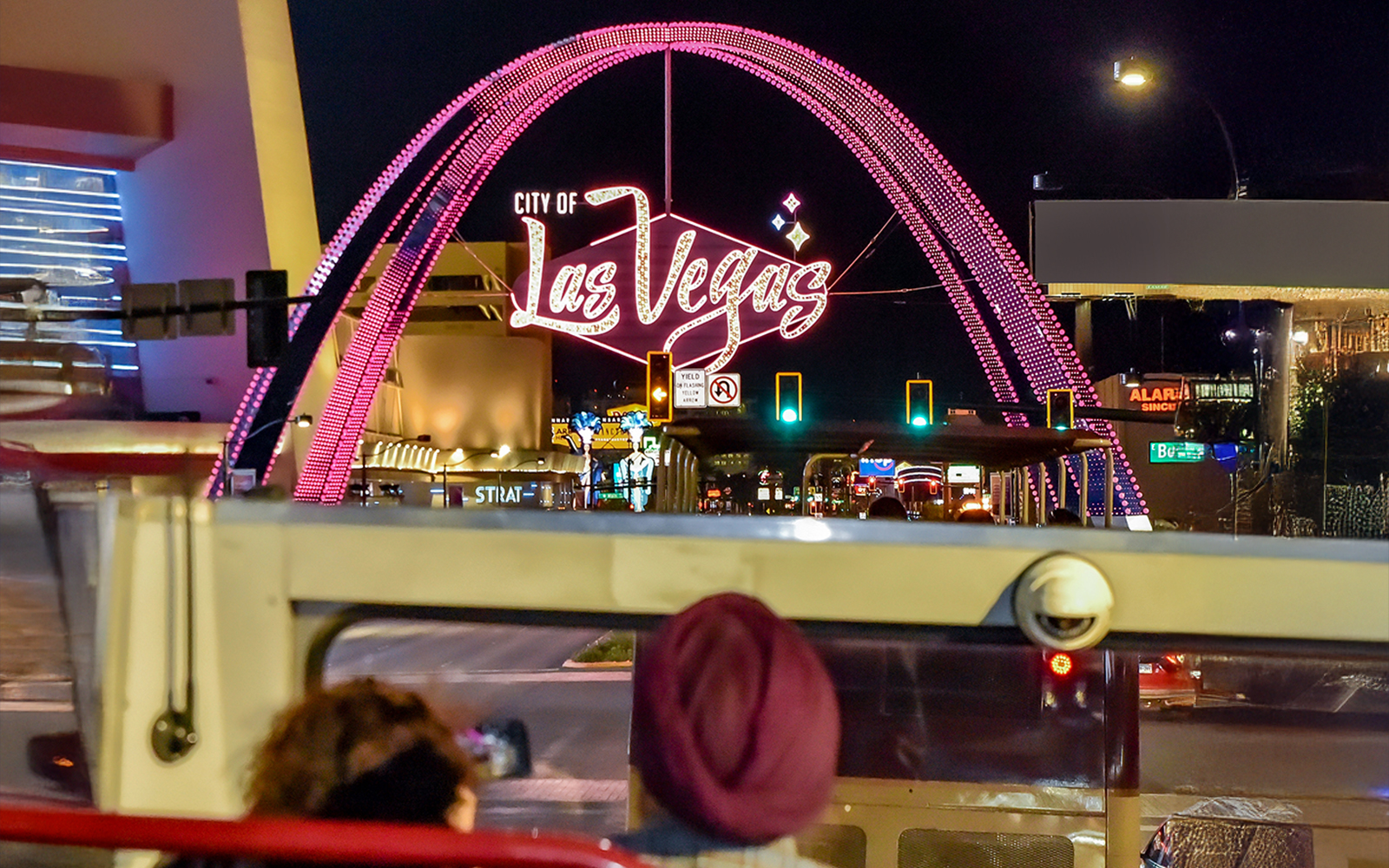 Open-top bus view of Las Vegas sign at night on Big Bus Tours.