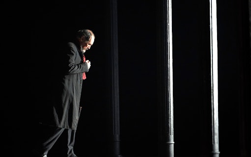 Man in dark coat standing under dim light, related to Dr Semmelweis.