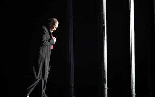 Man in dark coat standing under dim light, related to Dr Semmelweis.