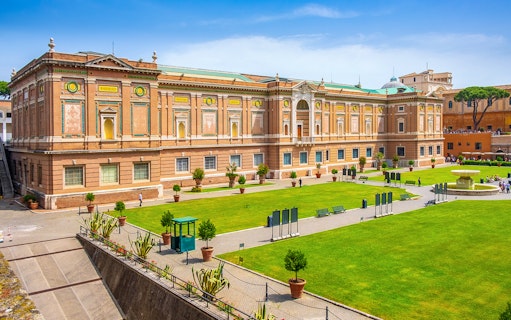Vatican Museums exterior with green lawn, part of small-group guided tour.