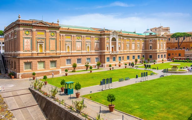 Vatican Museums exterior with green lawn, part of small-group guided tour.