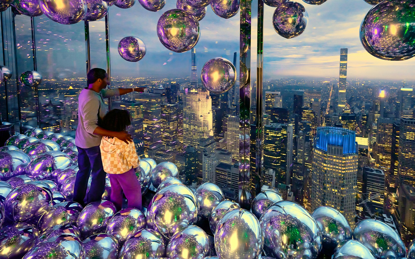 Father and daughter enjoying skyline view at Summit One Vanderbilt, New York City.