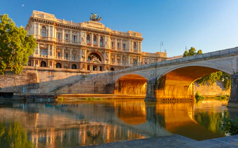 Palazzo di Giustizia and bridge over Tiber River in Rome at sunset.